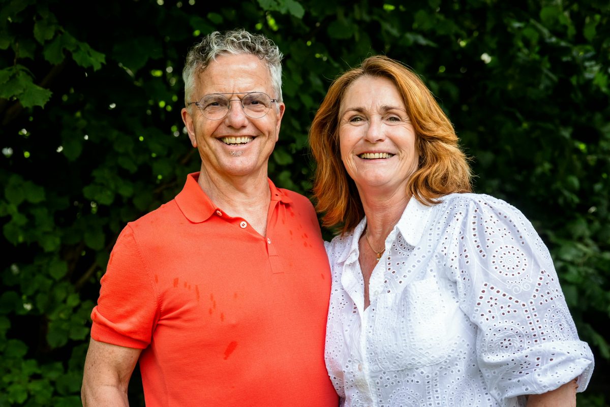 Pieter en Margreeth, lachend voor een groene haag